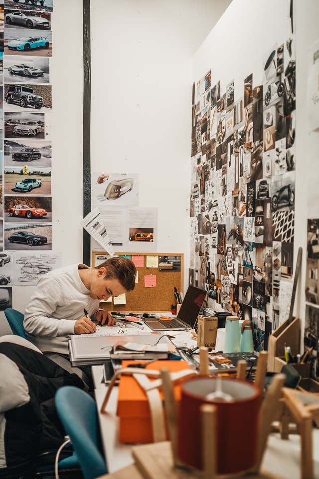 A man sitting on his chair sketching cars